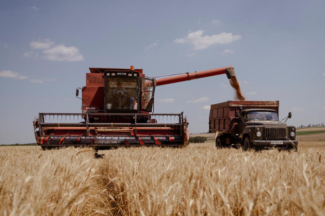 A harvester loading a food truck.