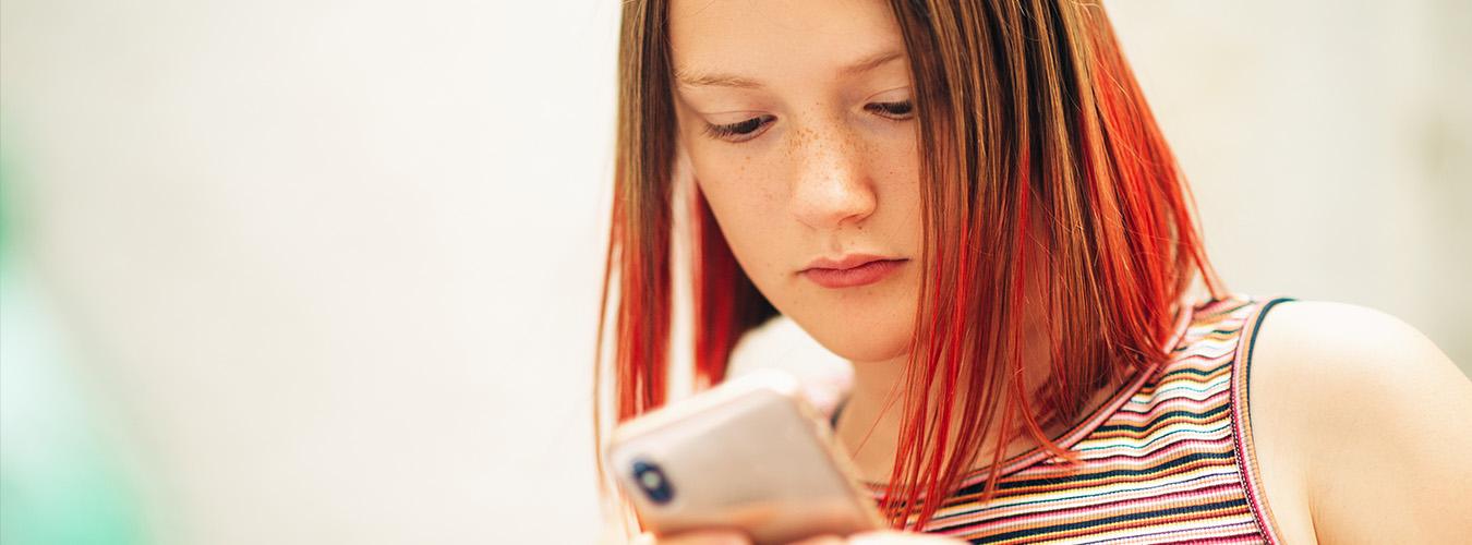 A young girl checks her cellphone
