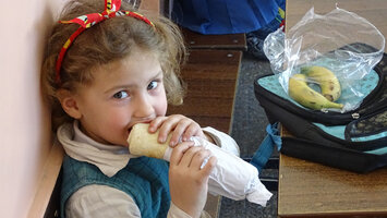 拿着学校营养餐的小女孩