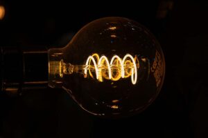 Photograph of a light bulb lit in a dark environment Photograph of a light bulb lit in a dark environment
