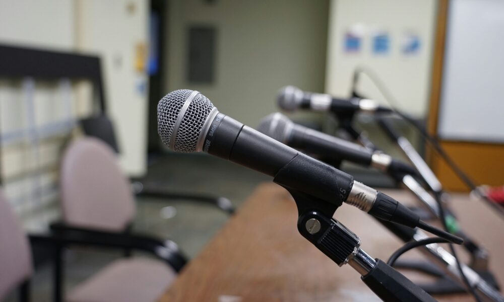 a set of microphones lined up at a table for a hearing