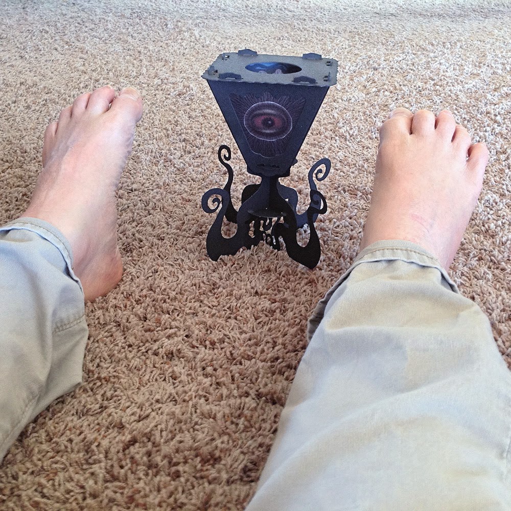 You got me! Cephalopod creature lantern looks down at the possible corpse of the artist, feet in the air.