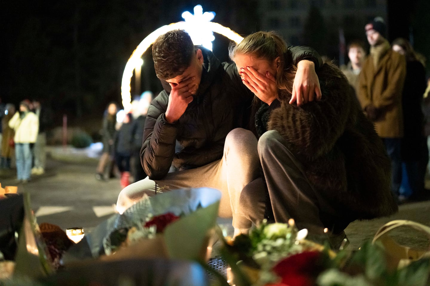 Mourners grieve at an impromptu memorial to those killed in a fire at a bar in the ski resort town of Crans-Montana, Switzerland, on Thursday, Jan. 1, 2026.