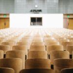 Quem “manda” dentro das universidades públicas brasileiras? Fotografia de cadeiras de madeira vazias em um auditório