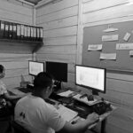 Como a burocracia molda (e limita) a saúde indígena Fotografia de dois trabalhadores realizando atividades administrativas.