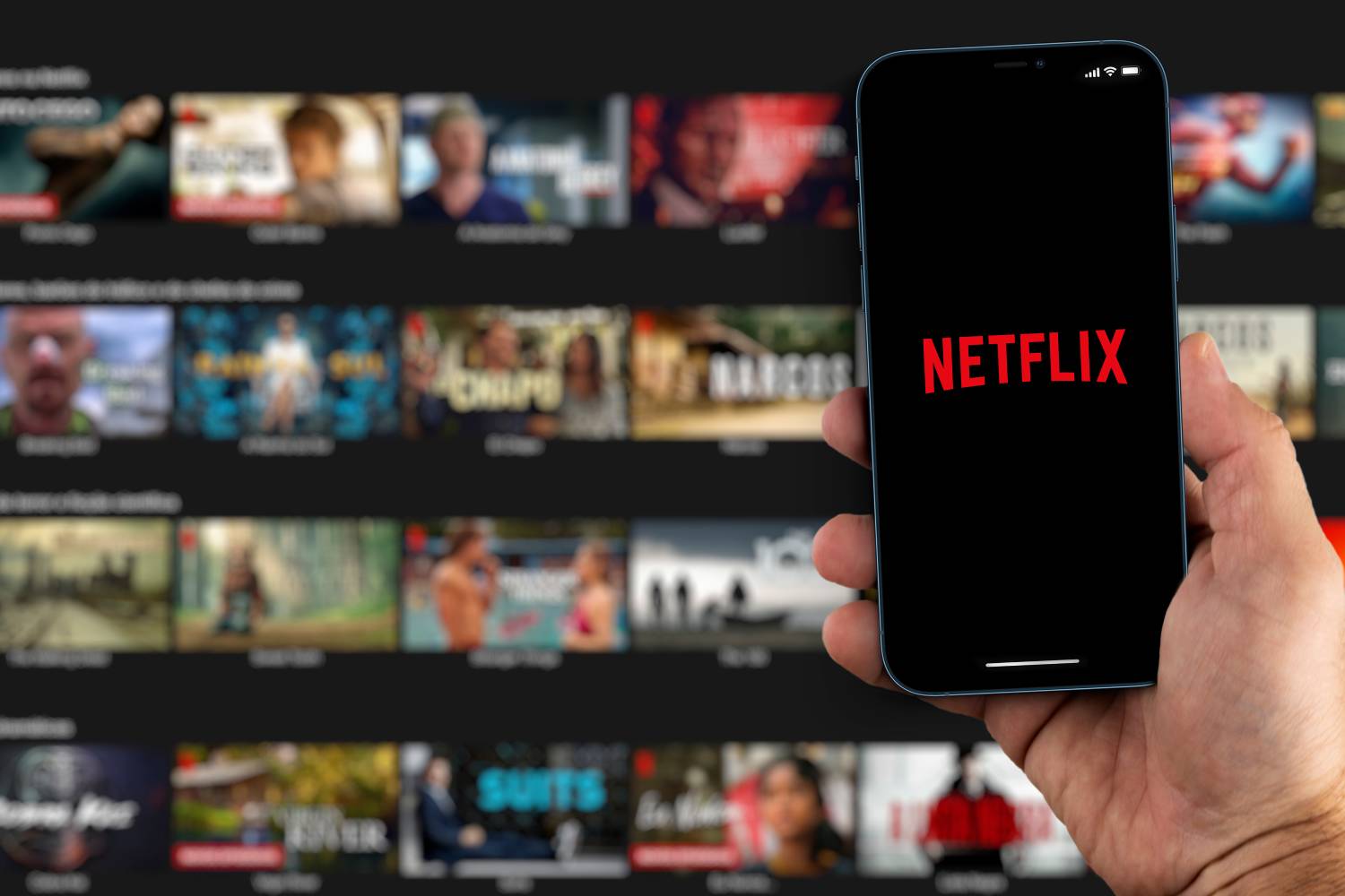 A person holding a cell phone with the Netflix app open.