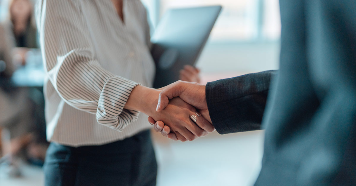 Two employees shaking hands in agreement, representing trust