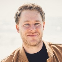 headshot of man smiling outdoors