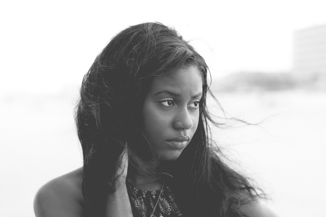 Sad African-American female at a windy beach