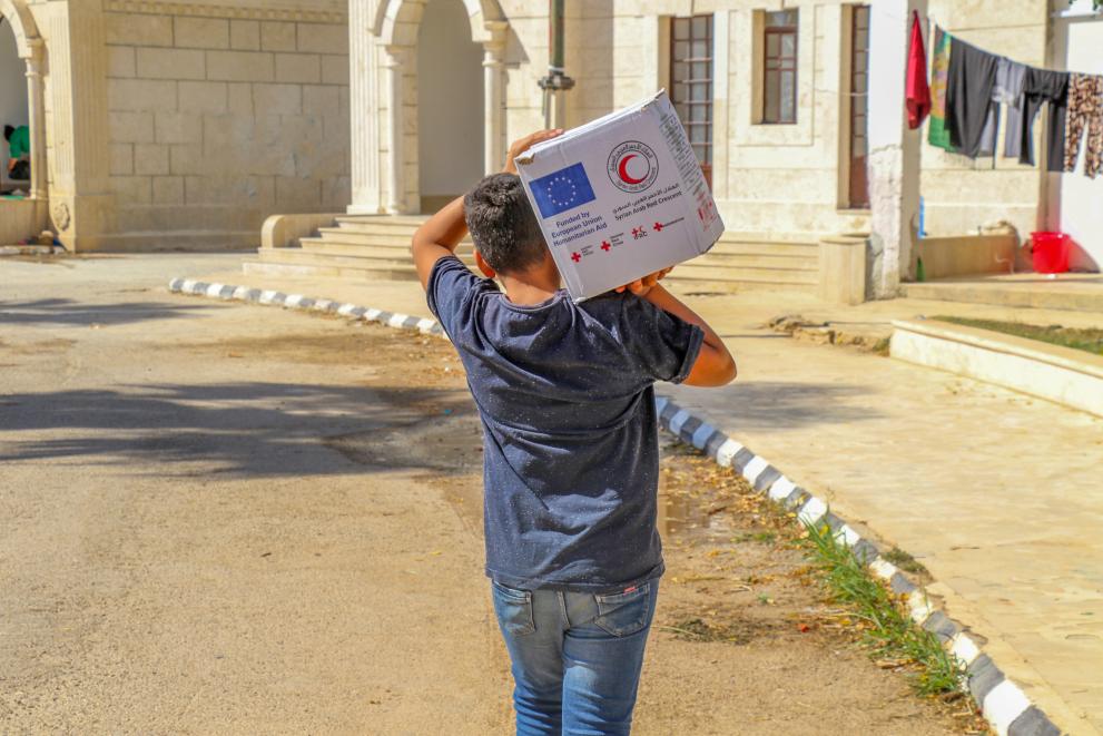 A person carrying a box on his shoulder.