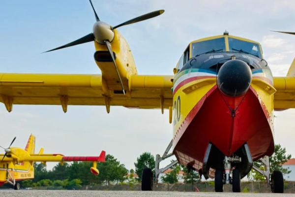 A firefighting plane seen from the front, in the back left another one.