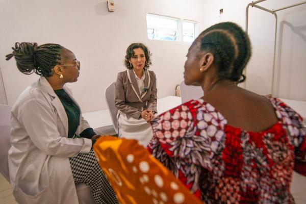 Commissioner Lahbib in conversation with 2 women, seeted in a room.