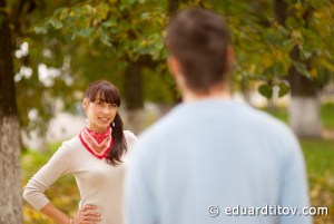 Smiling girl behind blurry boy against autumn landscape.