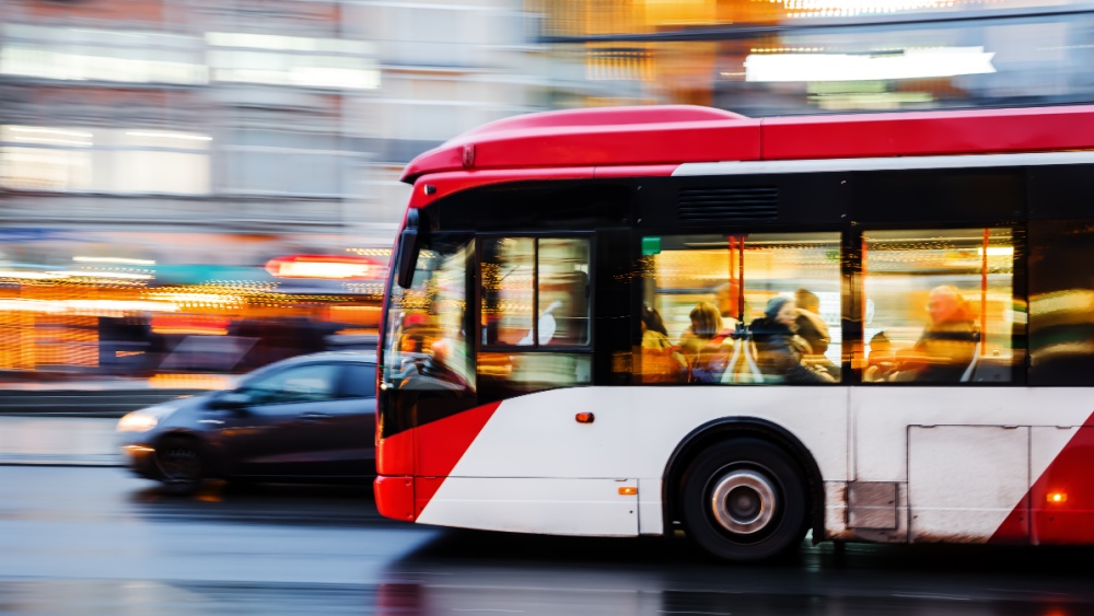 A car and a bus on a busy street.