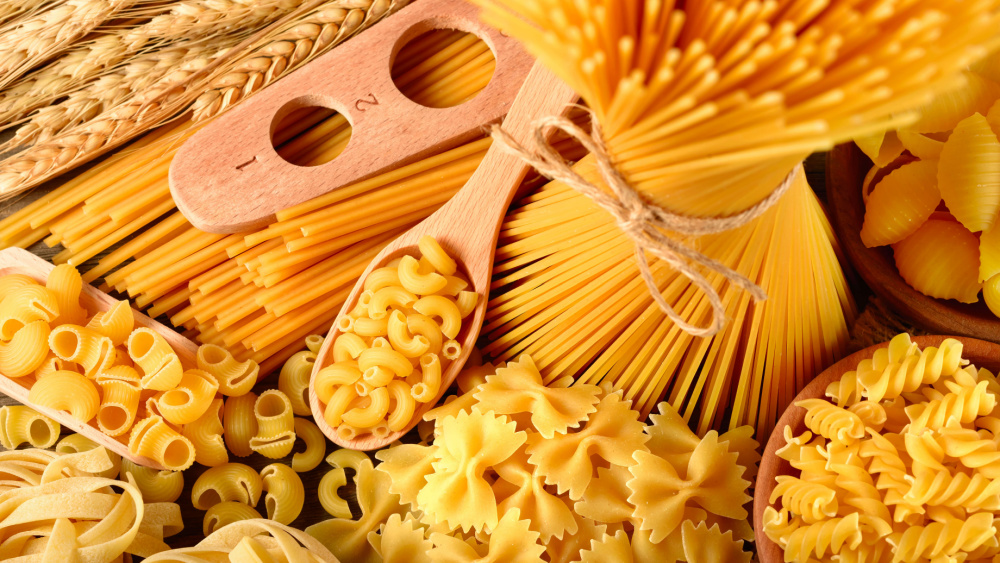 Different sorts of pasta on a wooden board.