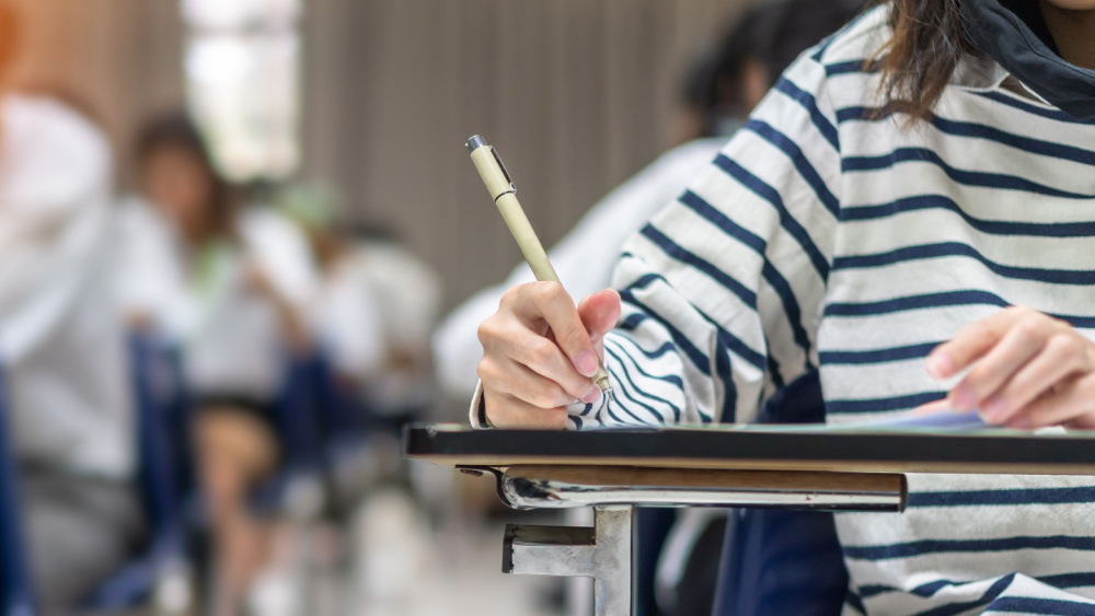 student writing at a desk