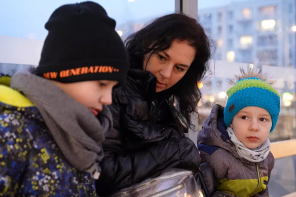 A Ukranian mother and her two sons sitting in a bus stop