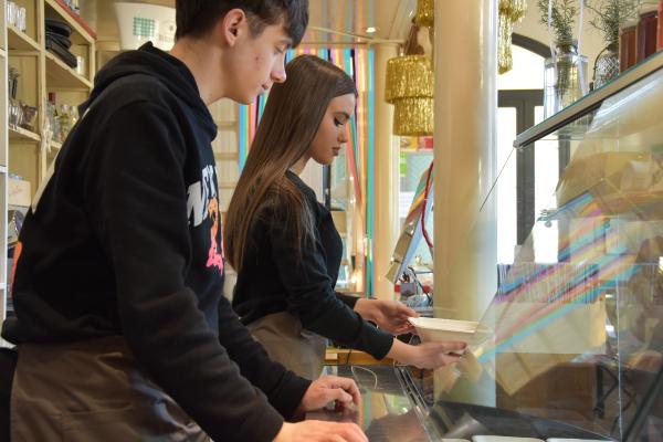 Two teenagers, male and female, working behind a bar