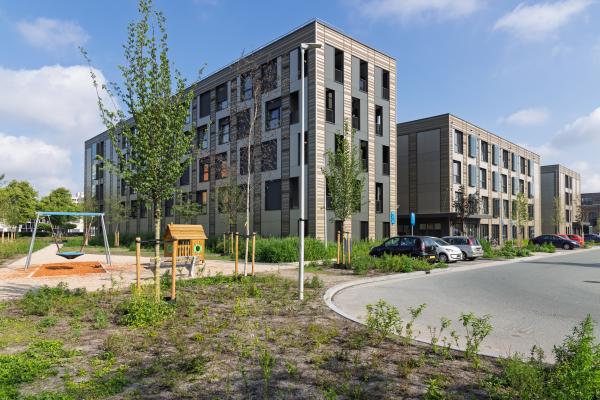 Modern modular housing in Utrecht, Netherlands, featuring multi-story temporary apartments with a playground nearby, addressing urban housing
