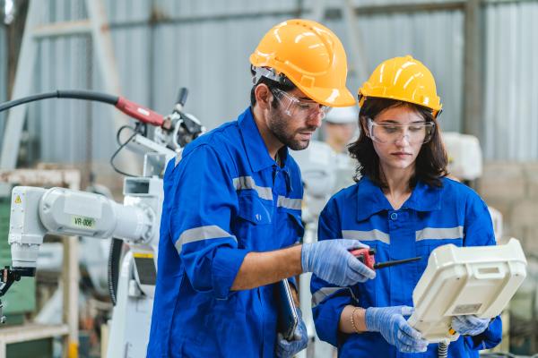 Testing new automation innovation tool for smart industrial, professional robotic engineers specialist maintenance and control robot arm in factory warehouse, technician teamwork working together