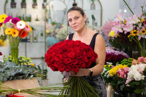 Lady holding a bunch of flowers in a flower shop