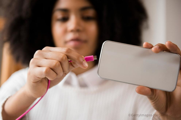 Woman connecting cable to smartphone