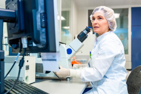 Woman looking at microscope in laboratory