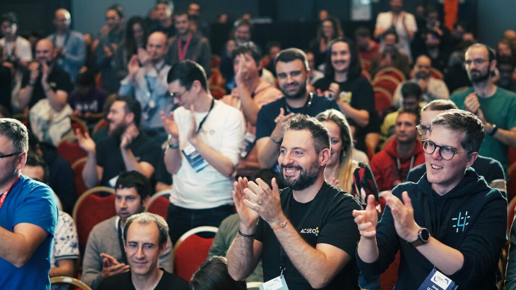 Public debout, applaudissant et souriant pendant une standing ovation