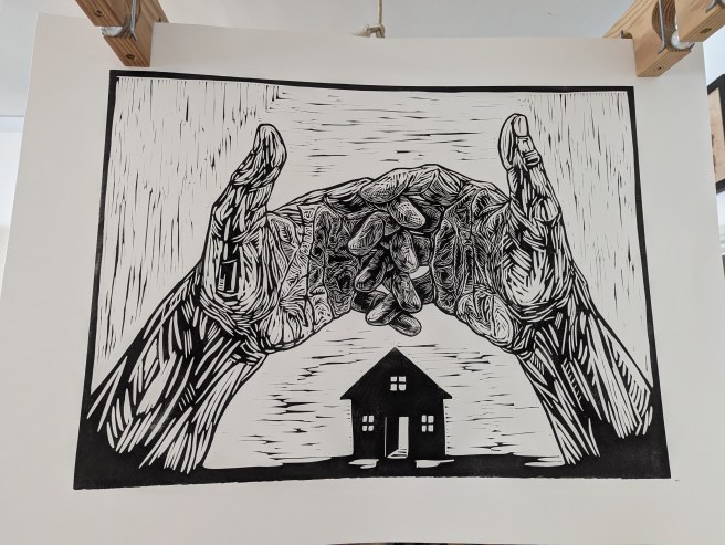 Linoprint of hands with intertwined fingers above the silhouette of a small building