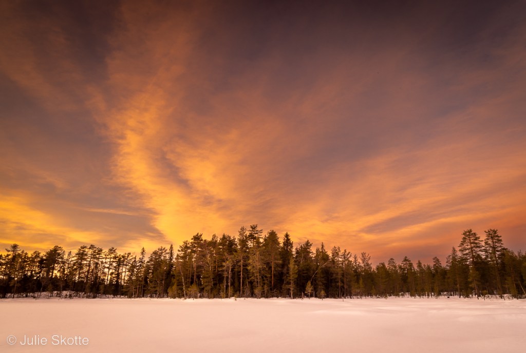 Landscape with snow and a colorful sunset.