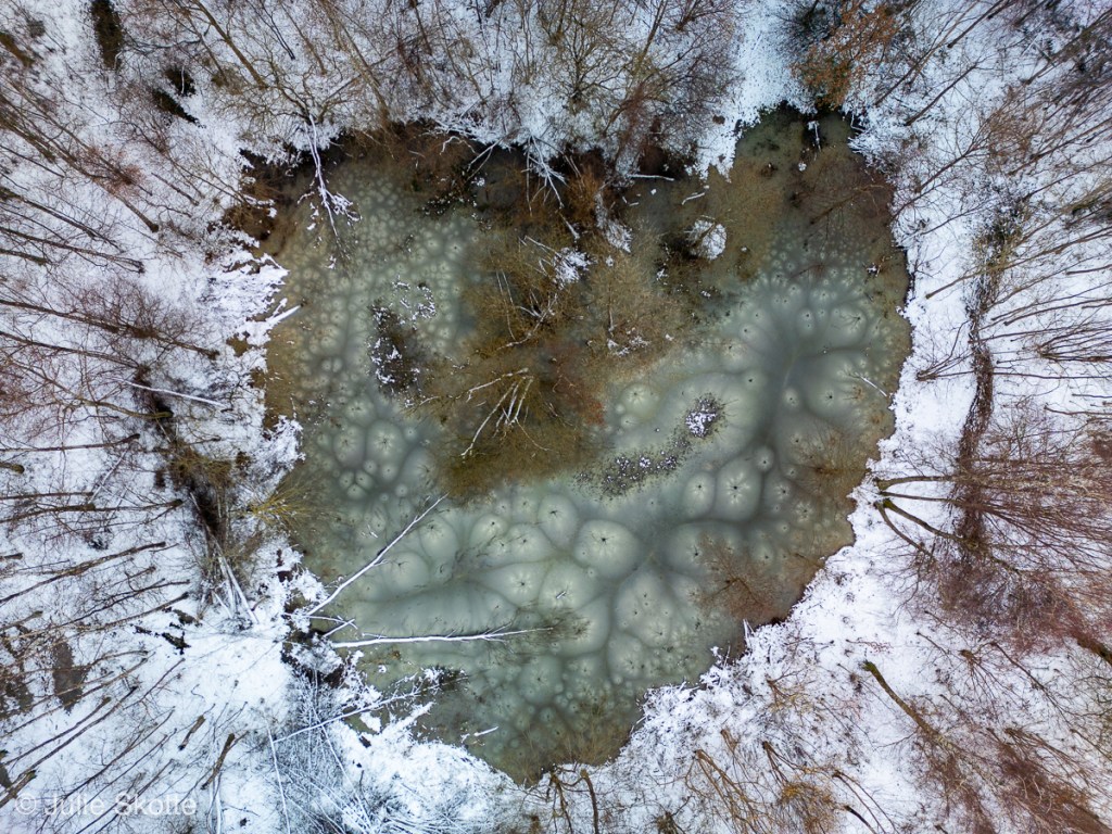 sø formet som et hjertre. Der er is på søen, som næsten er tøet, men der er fykdt med stjernemønstre. Lake stars.