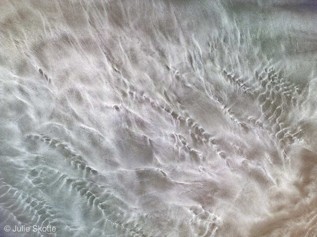 Drone billede af Saksun fjord på Færøerne. Nærbillede af mønstre i sandet.