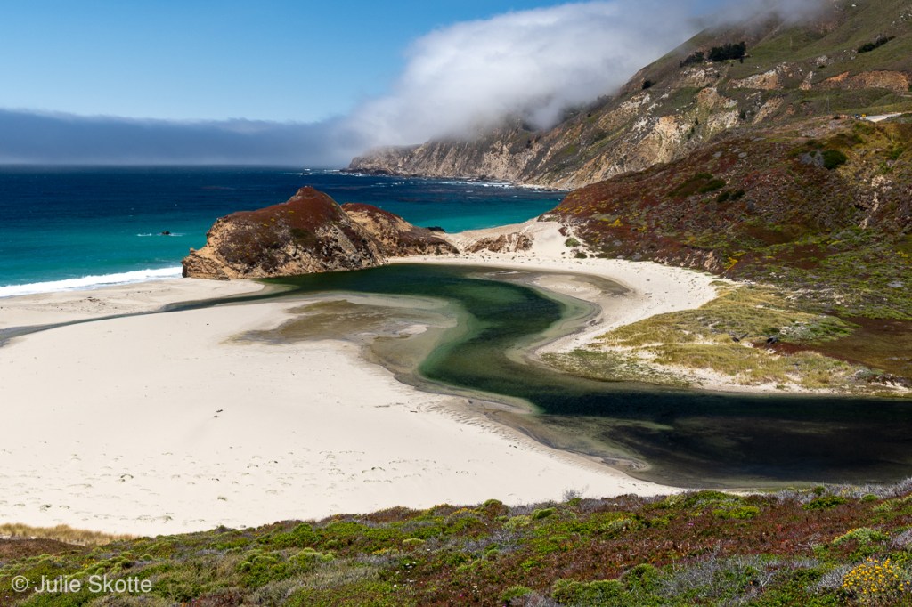 Flodusmunding, i turkist vand ved kysten i Big Sur.