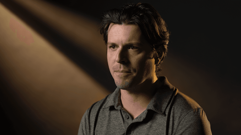 A person standing in a dimly lit area.