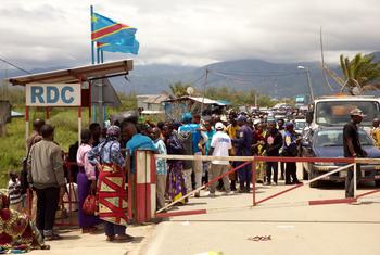 Pessoas que fogem da violência na zona de Bukavu, no leste da RD Congo, esperam para atravessar o posto fronteiriço de Gatumba para o Burundi