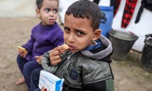 Crianças deslocadas comem biscoitos de alto teor energético num abrigo improvisado no centro de Gaza