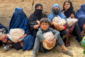 Mulheres e crianças seguram pão em Baghlan, norte do Afeganistão