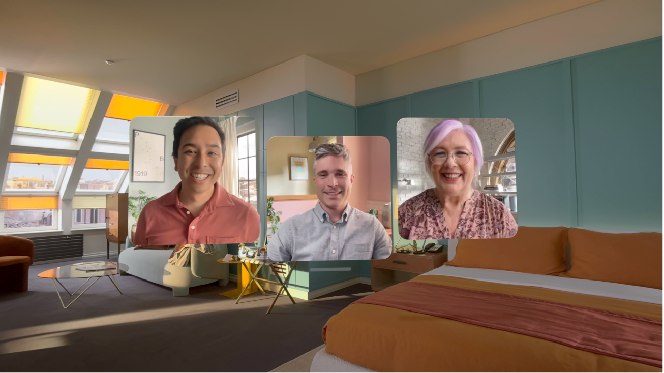 Una llamada de FaceTime en el Apple Vision Pro mostrando tres cuadros de otros participantes sobrepuestos en la habitación del usuario.