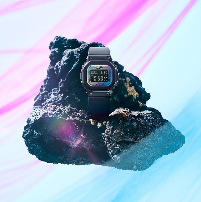digital watch positioned on a textured rock with a colorful background digital watch positioned on a textured rock with a colorful background