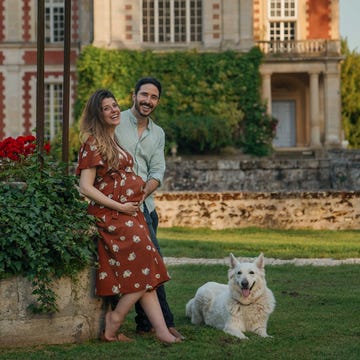 Smiling couple with dog in front of ivy-covered mansion. Smiling couple with dog in front of ivy-covered mansion.