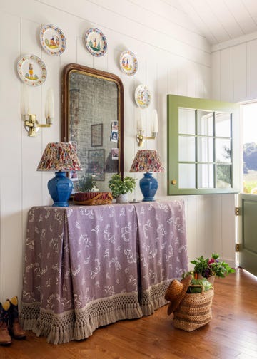 Entryway with decorative elements including a mirror, lamps, and plates on the wall. Entryway with decorative elements including a mirror, lamps, and plates on the wall.