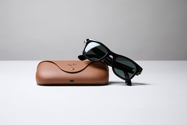 Black sunglasses resting on a brown case. Black sunglasses resting on a brown case.