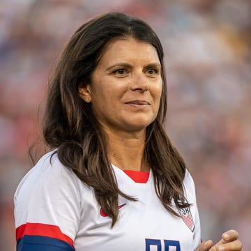 Mia Hamm mia hamm wears a white usa team jersey and looks to the right of the camera