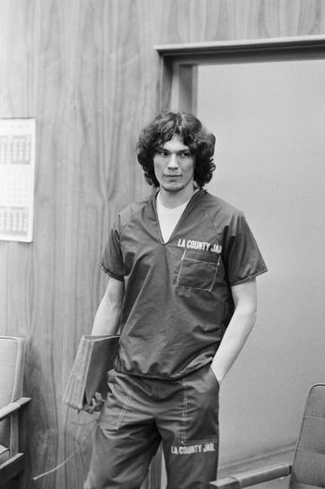 The Night Stalker Richard Ramirez in court richard ramirez holding a binder while standing in a courtroom