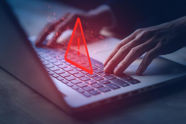 The image displays system hacked warning alert on laptop.