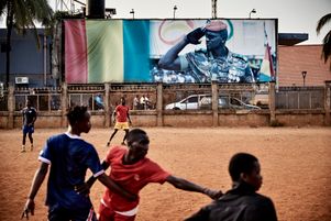 De jeunes guinéens jouent au football dans un terrain vague, sous l'œil vigilant de l’homme fort du pays : le président Mamadi Doumbouya, auteur d'un coup d'Etat militaire en septembre 2021. 