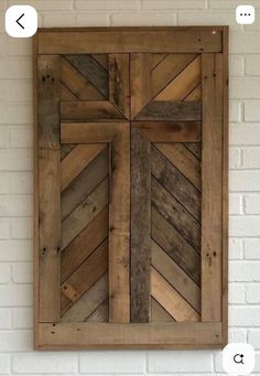 a cross made out of wooden planks hanging on a wall