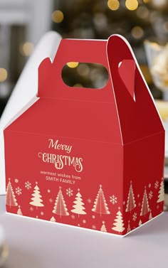 a red and white christmas box sitting on top of a table