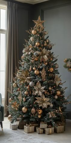 a christmas tree with gold and silver ornaments in a living room next to a window