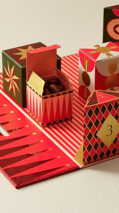 some boxes are sitting on top of a red and white striped tablecloth with gold decorations